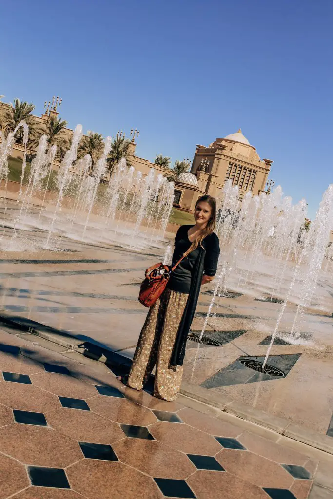 What to Wear in Dubai- desert safari and city lights. Monica in Abu Dhabi, wearing long flowy palazzo pants.