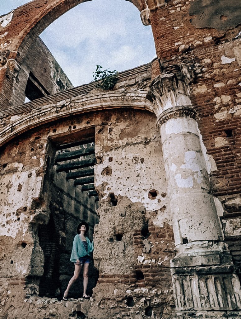 Monica exploring tall brick ruins.