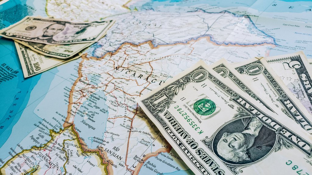 A map with money on it, symbolizing saving to travel (one of the simple bucket list ideas).