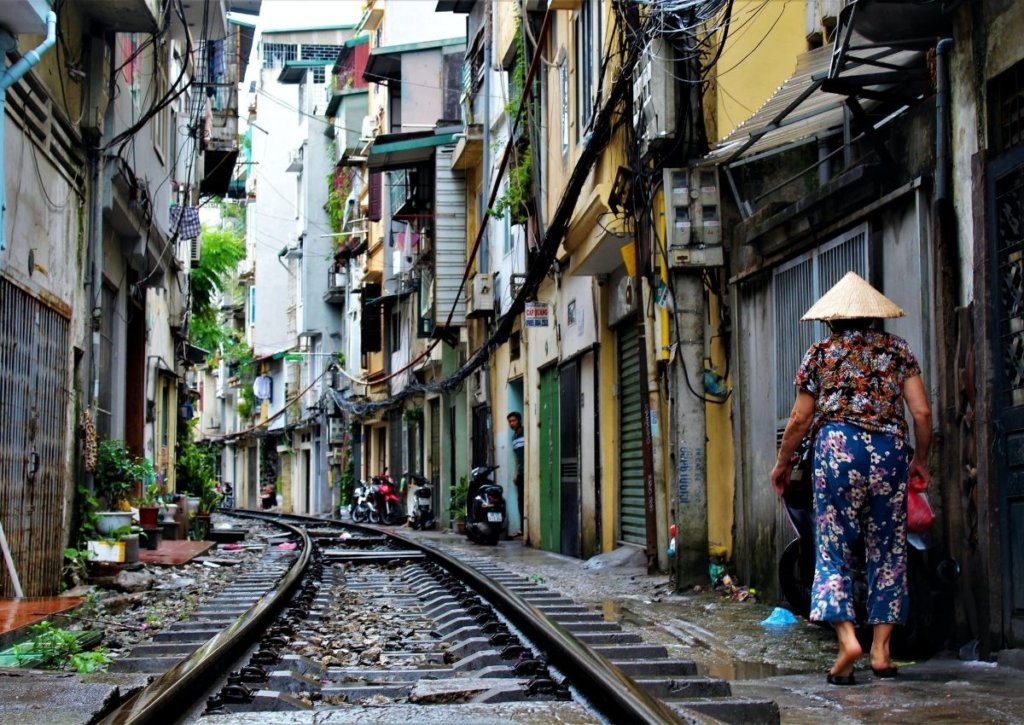 A woman walks in Vietnam next to the railroad.