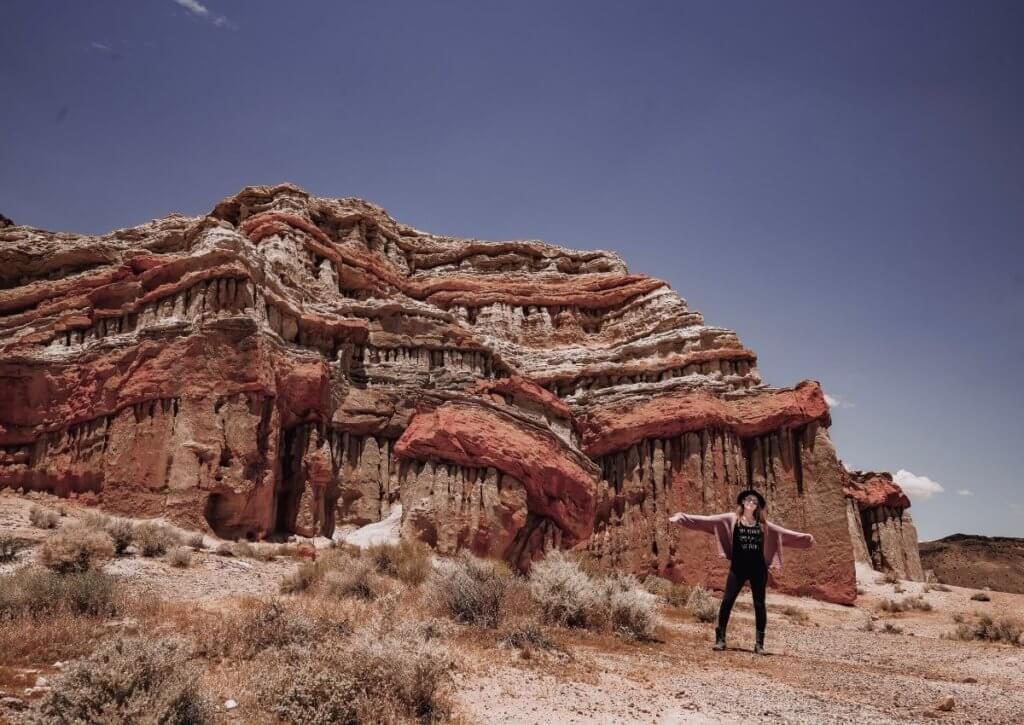 Monica in front of red rocks at Red Rock Canyon, one of the best things to do in the Mojave Desert.