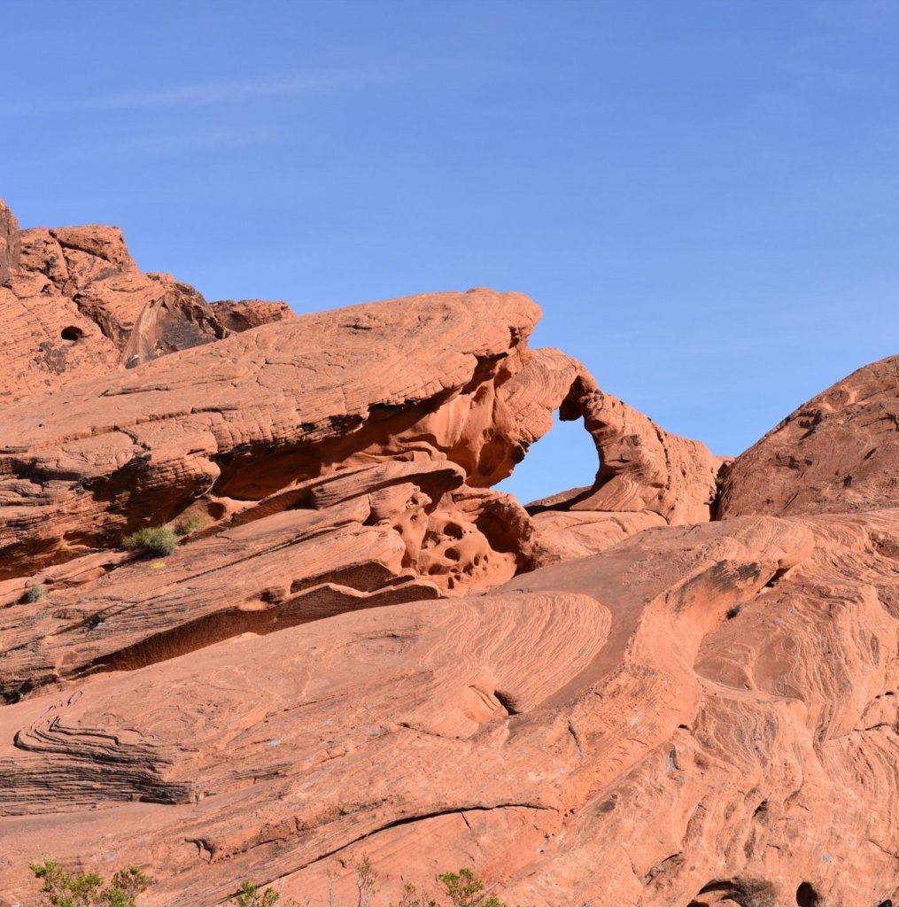 Valley of Fire State Park Arch Rock in front of blue sky.