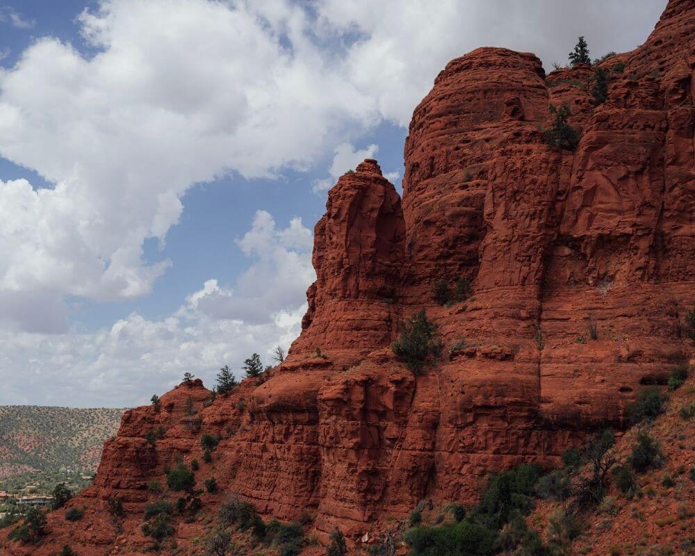 The red mountains of Sedona in front of cloudy skies.