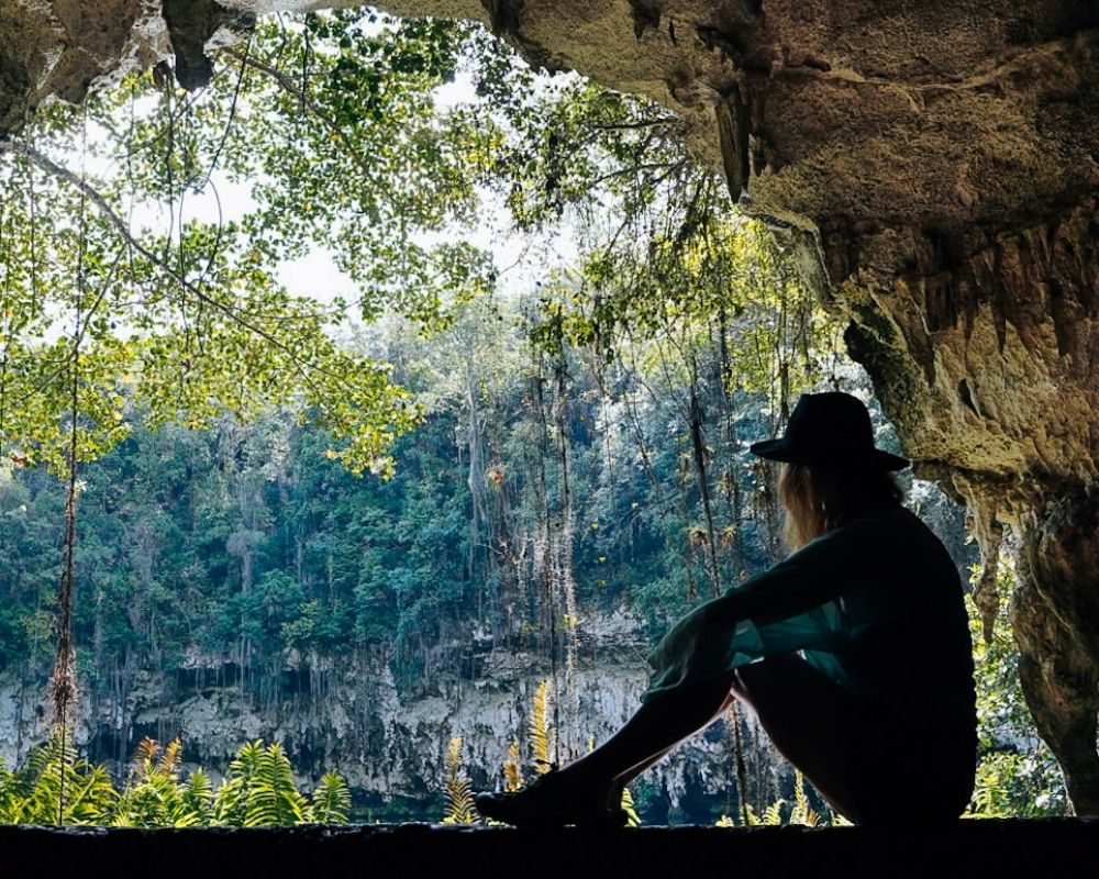 Monica seated on the rock, looking out at the fourth lagoon at the Dominican Republic caves