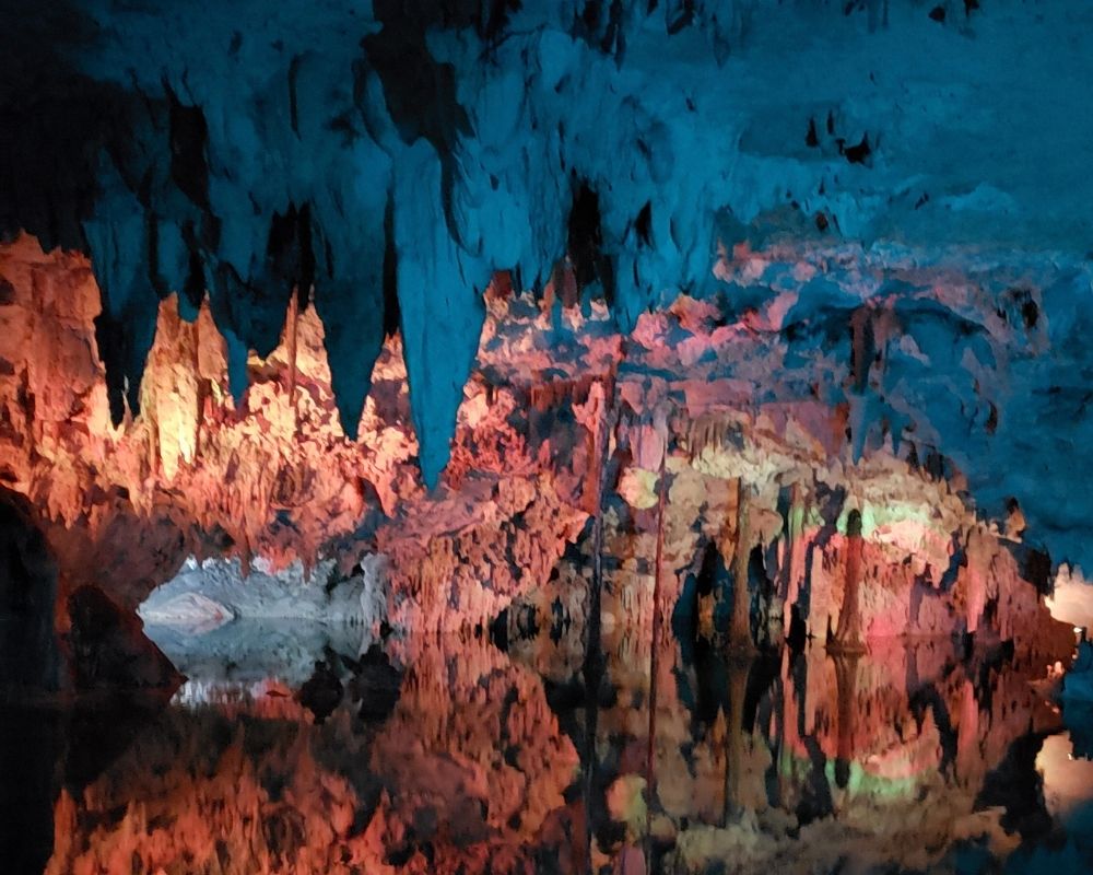 Cenote Caracol, illuminated blue and gold cavers.