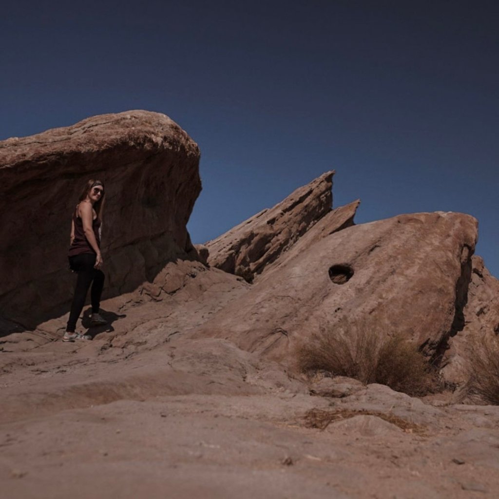 Monica in front of the Vasquez Rocks, with the tallest peak in the distance.