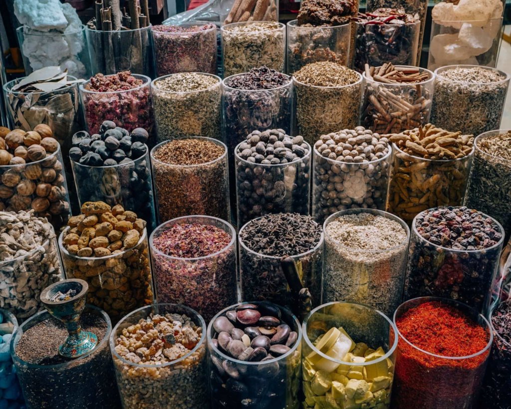 Colorful red, yellow, and tan spice bins in Old Dubai's souks.