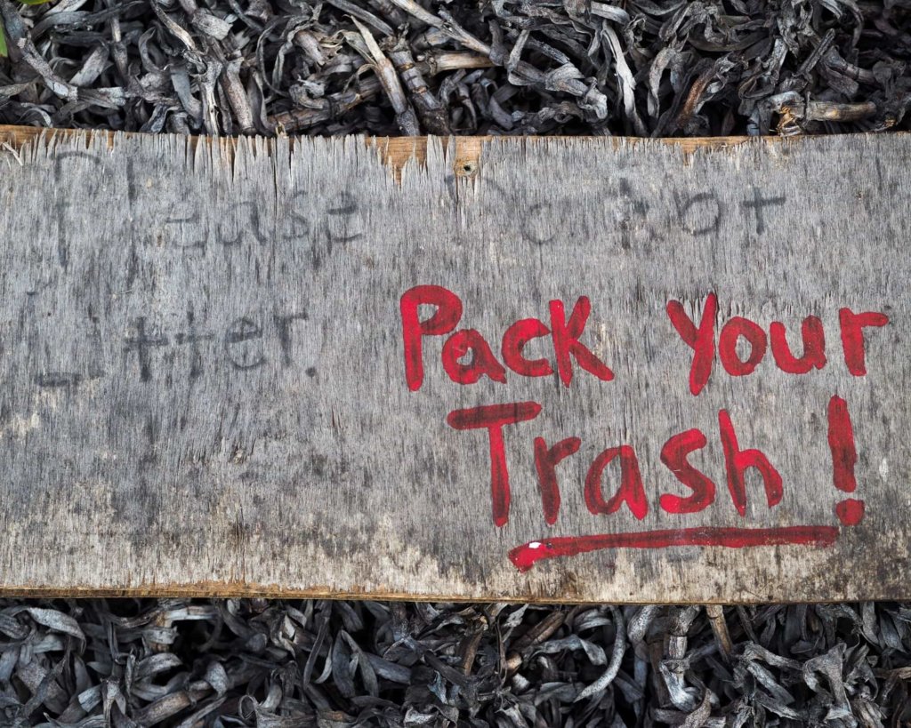 A sign reading "Pack your trash!"