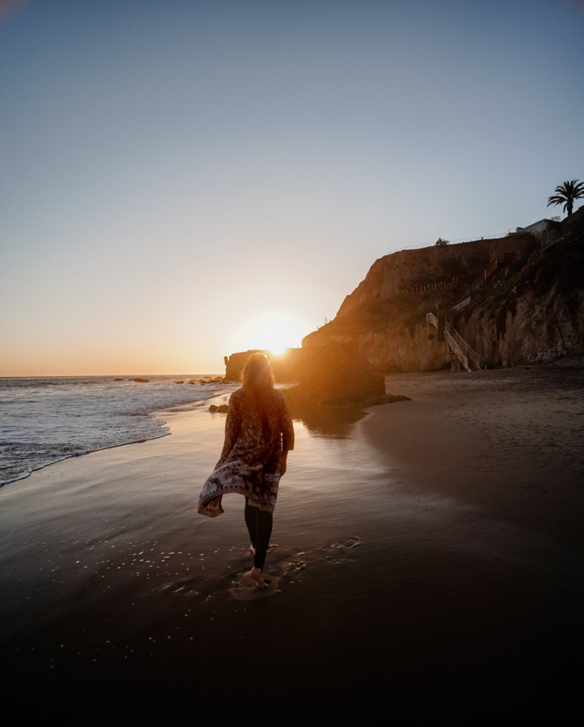 Monica walking in the golden glow of sunset on El Matador State Beach, Malibu California.