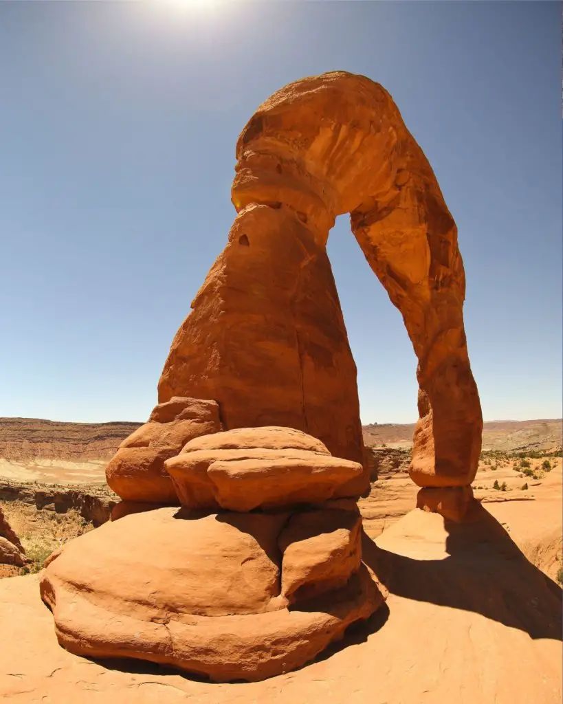 One of the most famous and Best Hikes in Arches National Park, to Delicate Arch, tall and rainbow-shaped.