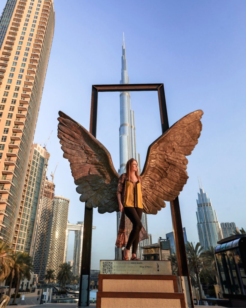 Monica exploring the public art in Dubai, with the Burj Khalifa towering in the background.