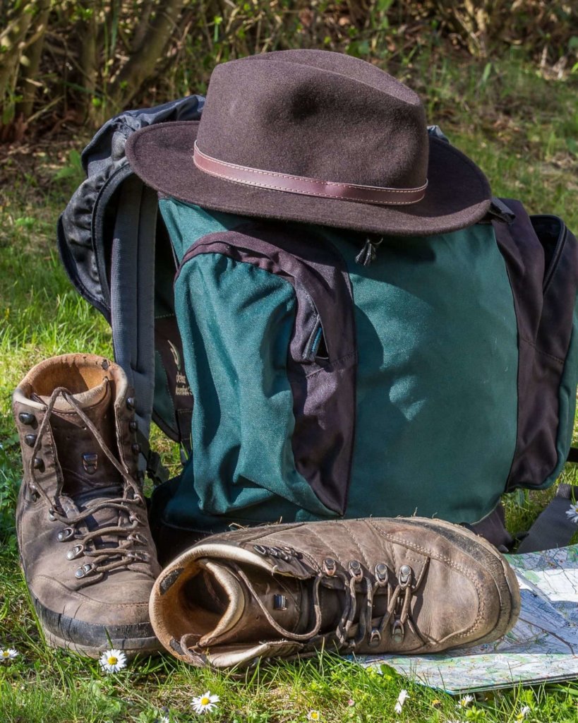 Backpack, hiking boots, and hat - Carry On Only Travel Tips.