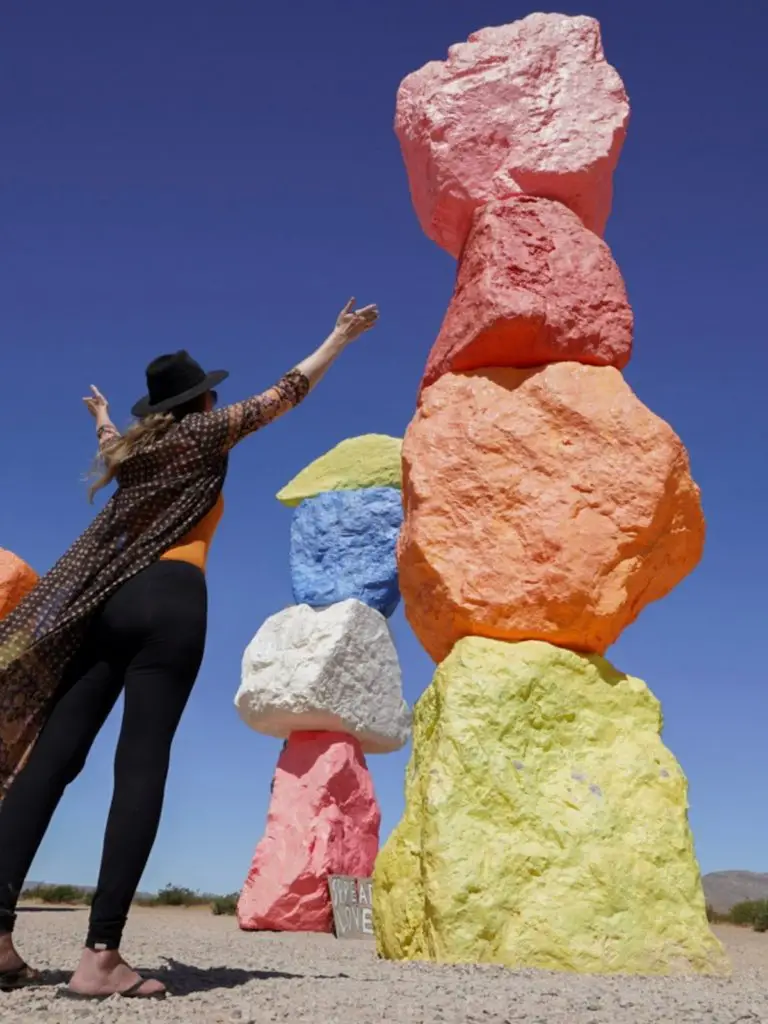 Monica in front of the Colorful rock sculptures, admiring how tall they are.