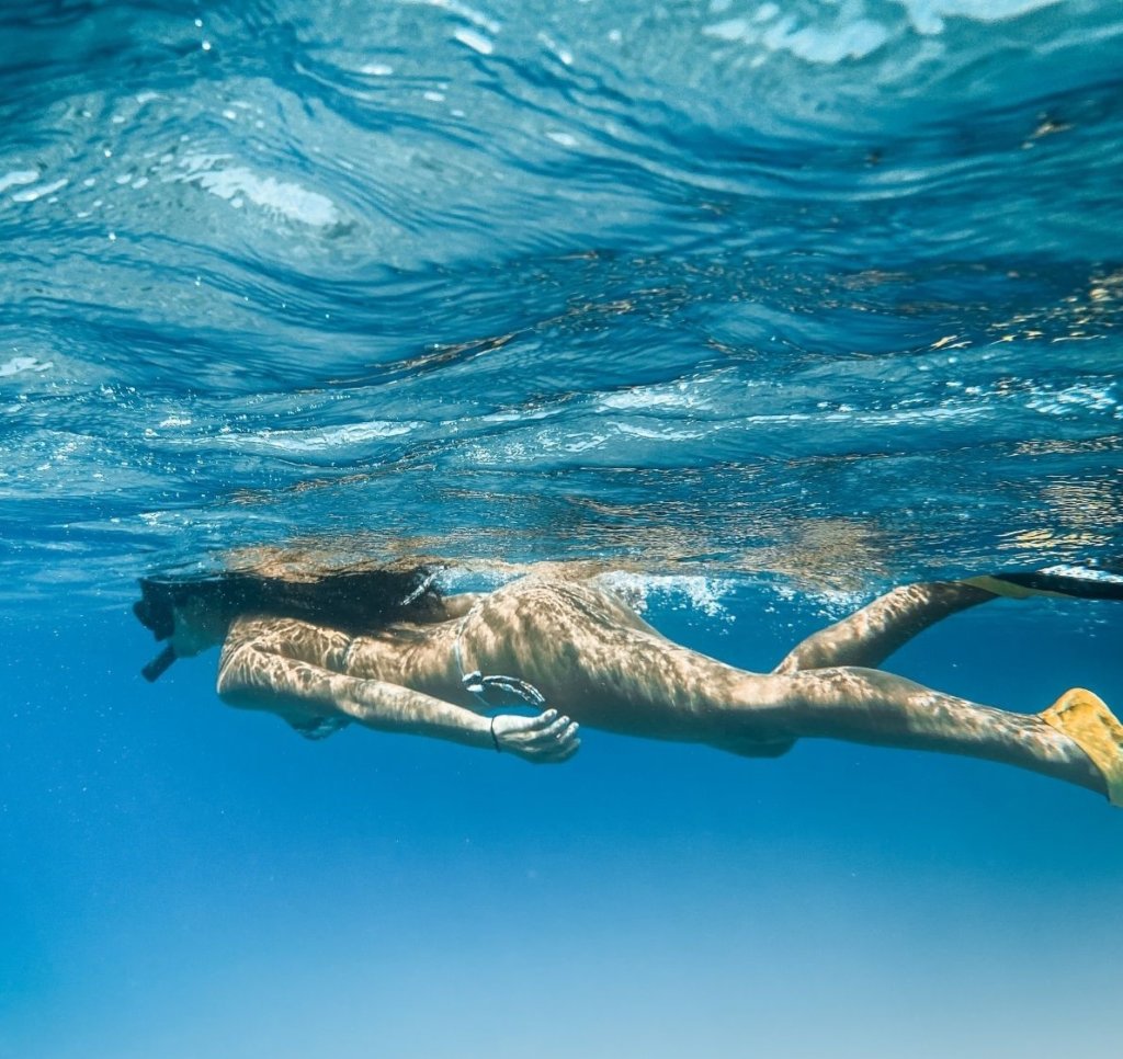 A girl snorkeling in the best Aruba snorkeling beaches.