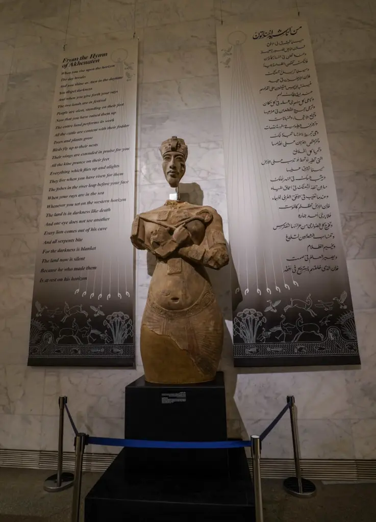 A large sculpture seen  while Visiting the National Museum of Egyptian Civilization in Cairo, Egypt. The sculpture stands in front of English and Arabic script.