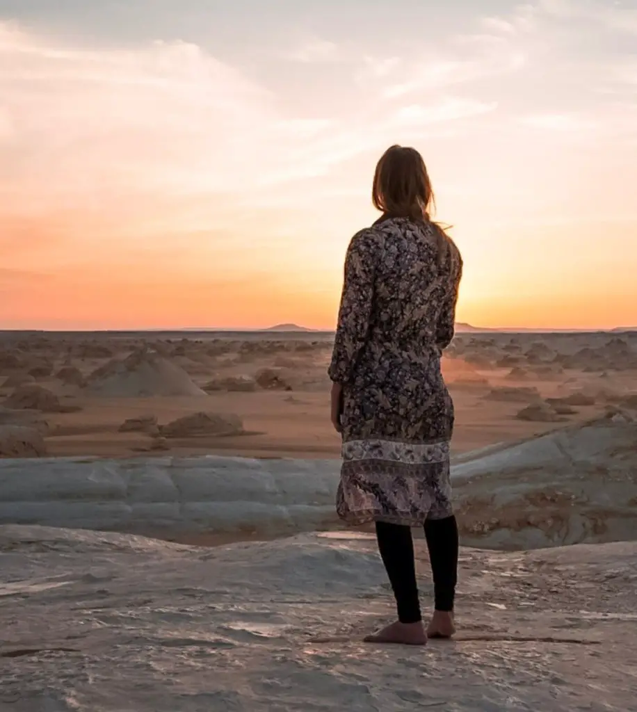 Monica Visiting the White Desert National Park in Egypt, watching the sunset – A Travel Guide to the Black and White Desert.