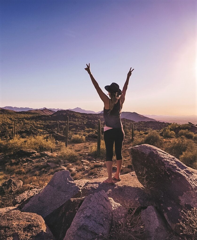 Monica gazing out into the wilderness at the South Mountain Preserve at sunset - one of The Best Things to Do in Phoenix.