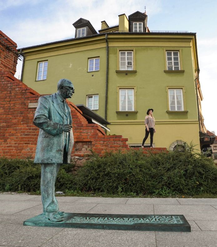 Monica behind the Jan Zachwatowicz statue in Old Town, one of the best things to do in Warsaw.