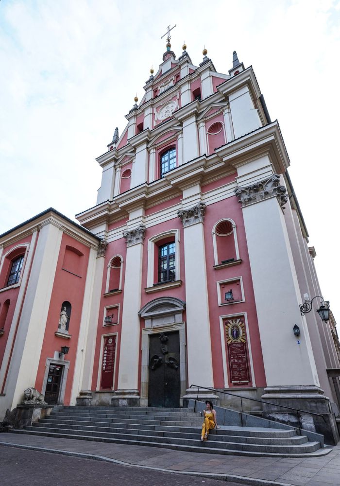 Monica exploring the colorful Old Town buildings during her one day in Warsaw.