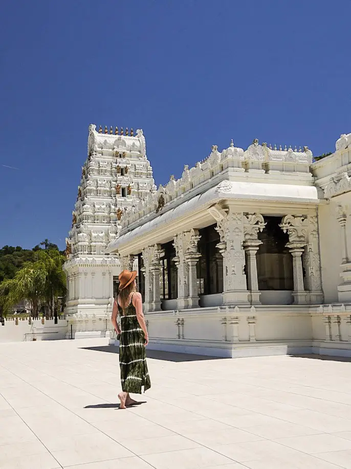 Monica exploring a white Hindu temple against a blue sky.