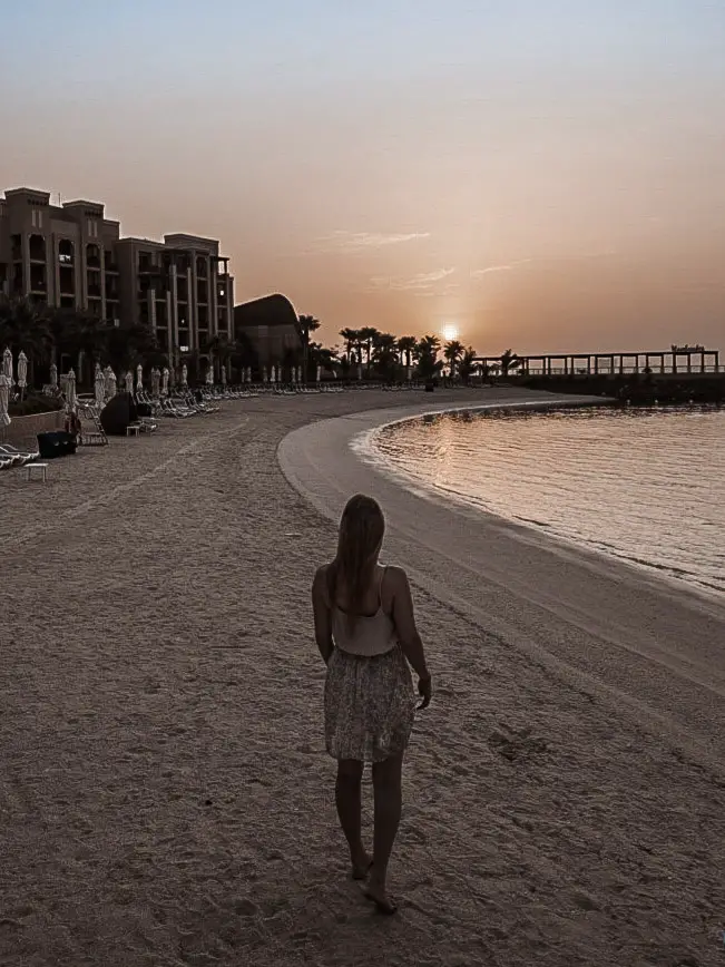 Monica walking the beach at sunrise, one of the best Places to Visit in Ras Al Khaimah.