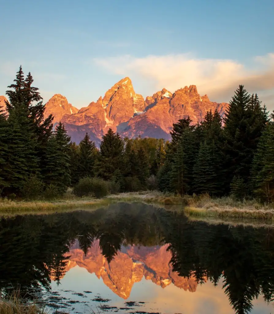 The Grand Tetons reflecting on the calm water, on A Salt Lake City to Yellowstone National Park Road Trip.