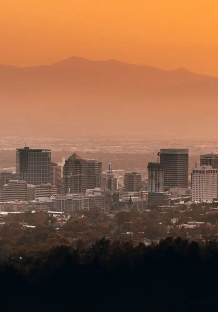 A pink sunset over the Salt Lake City skyline - where to start your Salt Lake City to Yellowstone National Park Road Trip.