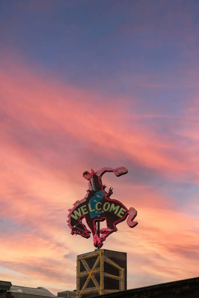 A neon sign above the Cowboy Bar at Jackson - one stop on your Salt Lake City to Yellowstone National Park Road Trip.