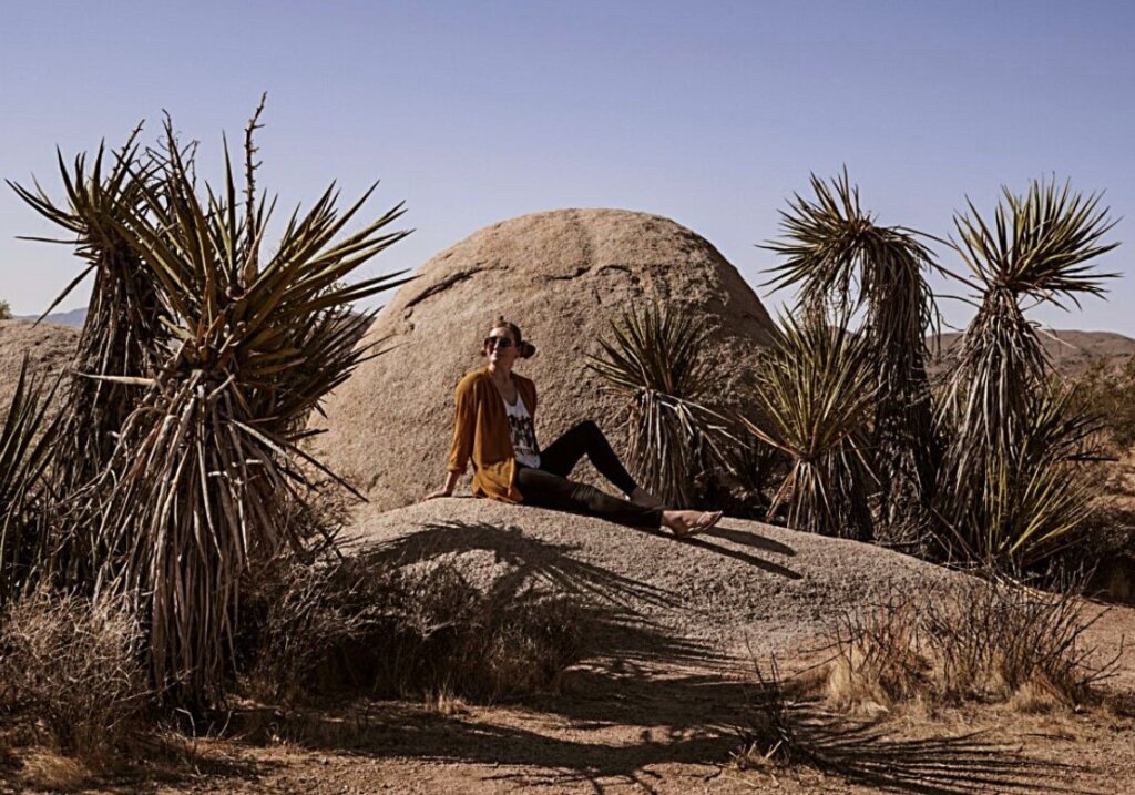 Monica on a rock in the desert sun on A San Diego to Joshua Tree Road Trip.