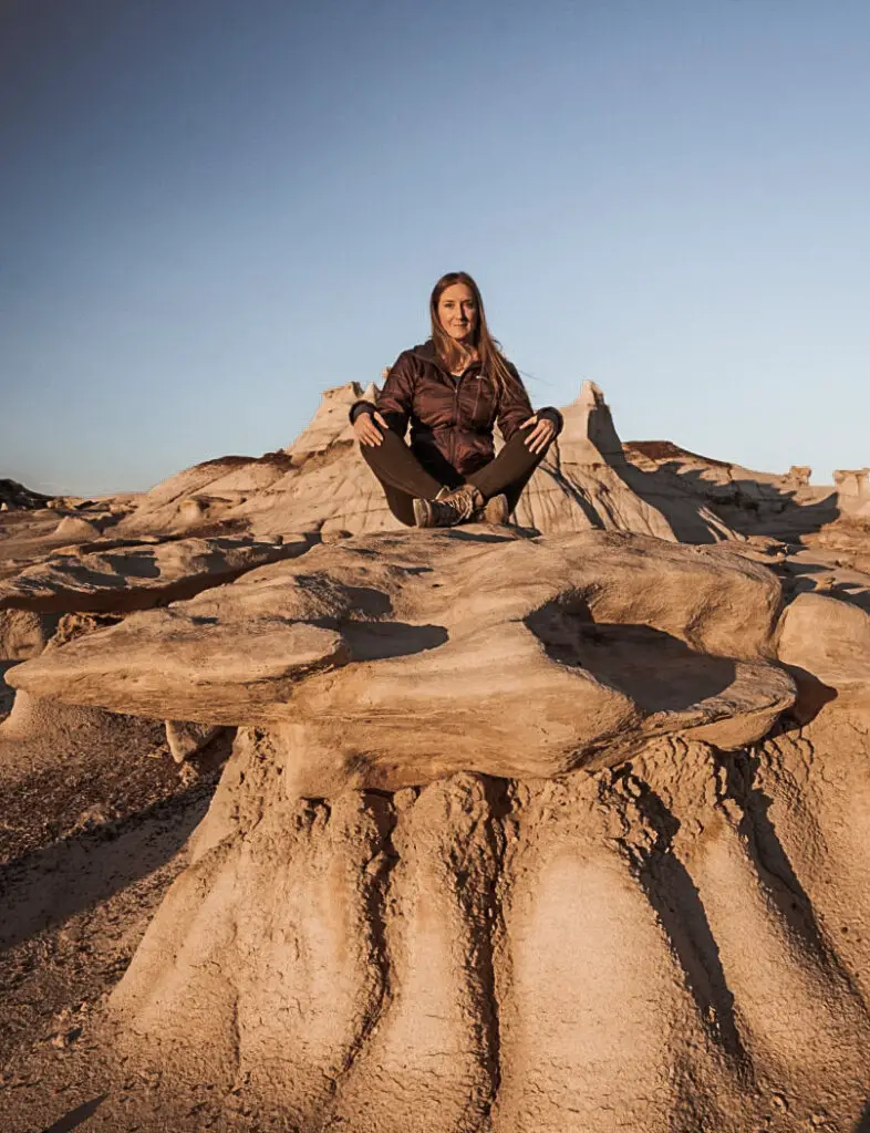 Monica on sandstone rocks at sunset, a must see after your Albuquerque to Santa Fe Road Trip.