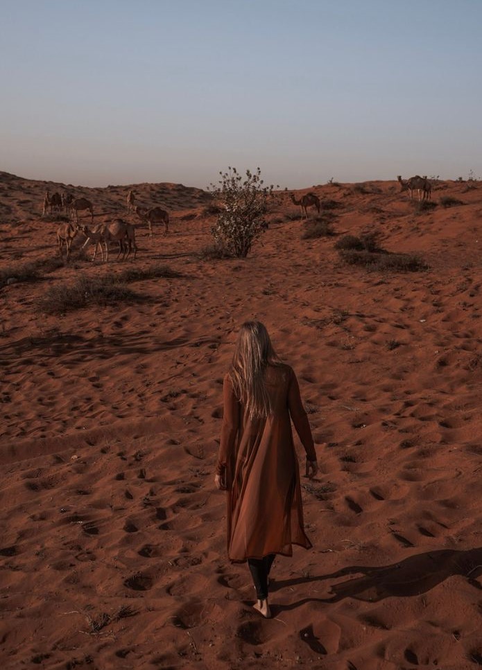 Monica in the beautiful orange sandy Dubai Desert - one of the best reasons to visit Dubai.