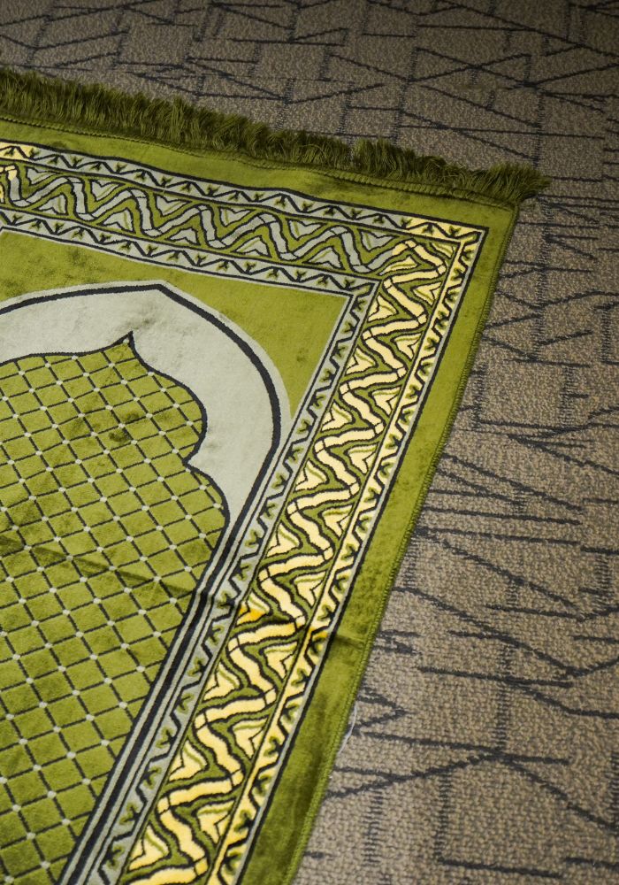 A green prayer rug for Muslims - who should not be disrespected when in Dubai. Ten things not to do in Dubai.