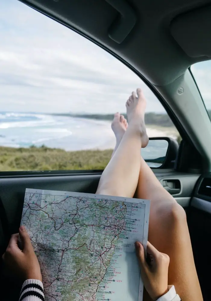 Things to Do on a Road Trip with Friends - girl planning the travel route on a map.