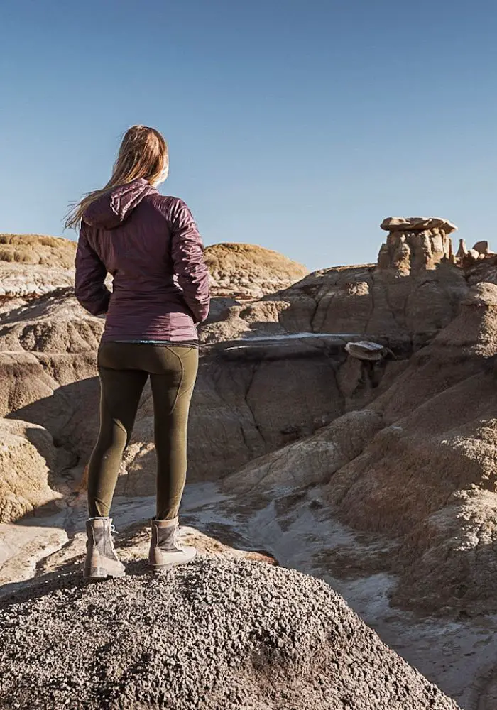 Monica exploring the Bisti Badlands / De Na Zin Wilderness, standing on a rock.