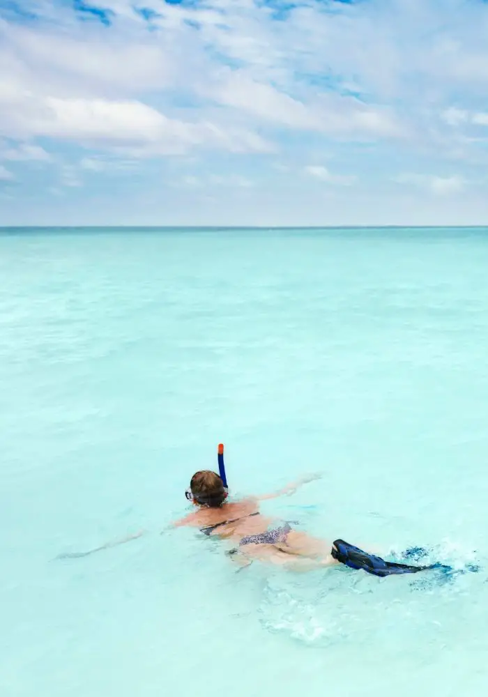A girl snorkeling Peanut Island Florida in the sun.