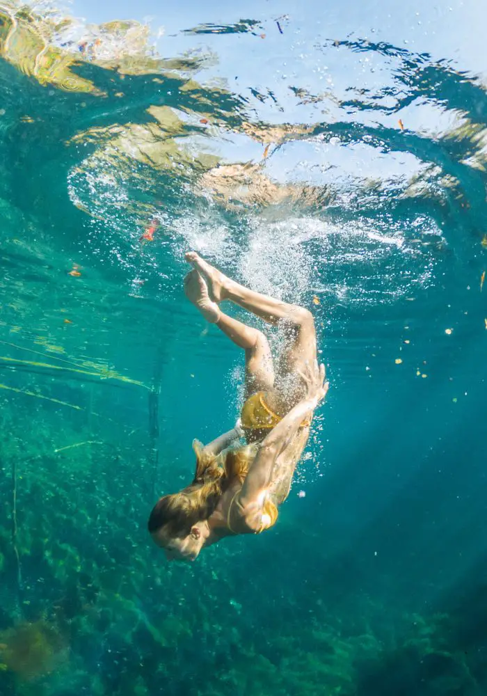 A girl underwater in a cenote near Cancun's natural cenotes. 