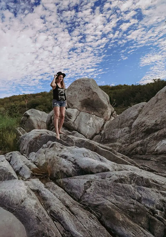 Monica on the white rocks near Cabo's rugged mountain terrain.