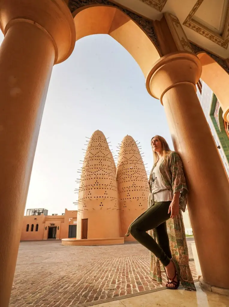 Monica standing in front of the Pigeon Towers, a worthy stop on A One Day in Doha Itinerary.
