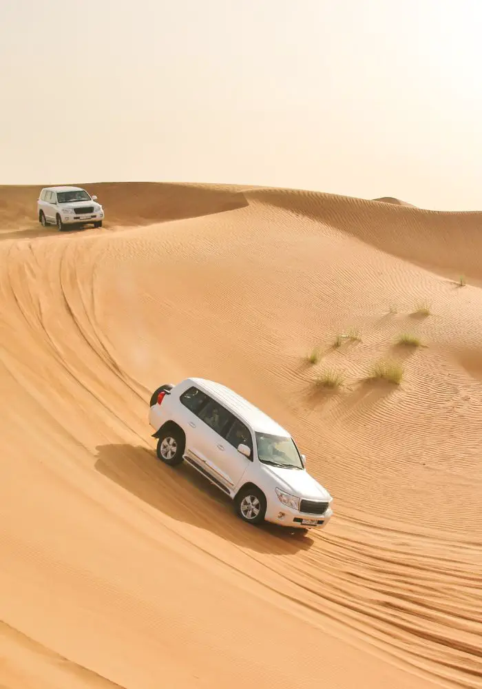A Liwa Desert Safari car driving across the steep dunes.