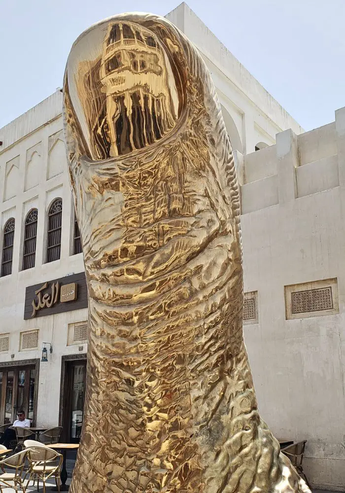 The giant gold Le Pouce sculpture, one of the best Places To Visit in Doha, Qatar.