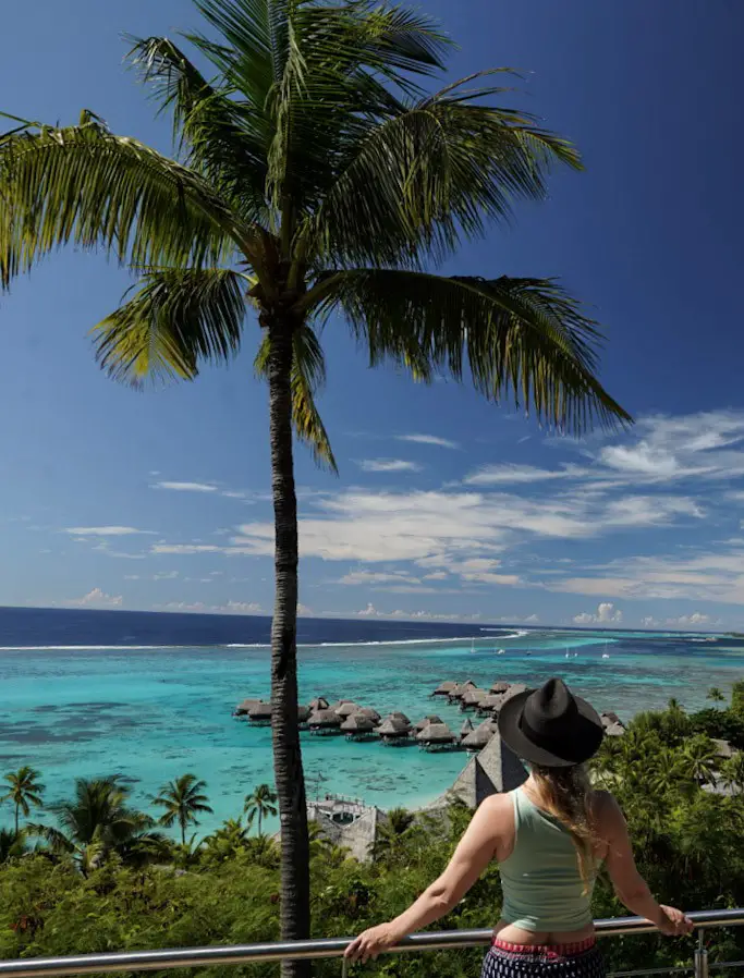 Monica overlooking the overwater bungalows in Moorea - which you can book on The Best Trip Planning Websites for Travelers.