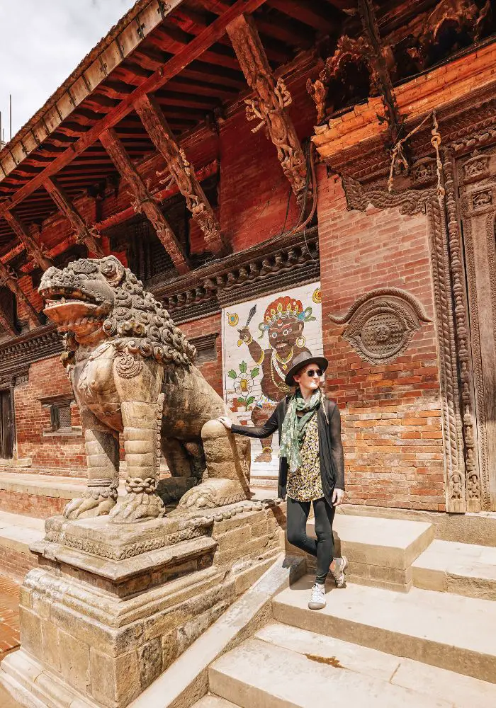Monica in a hat, scarf, and sweater at Patan Durbar Square - What to Wear in Nepal for Women.
