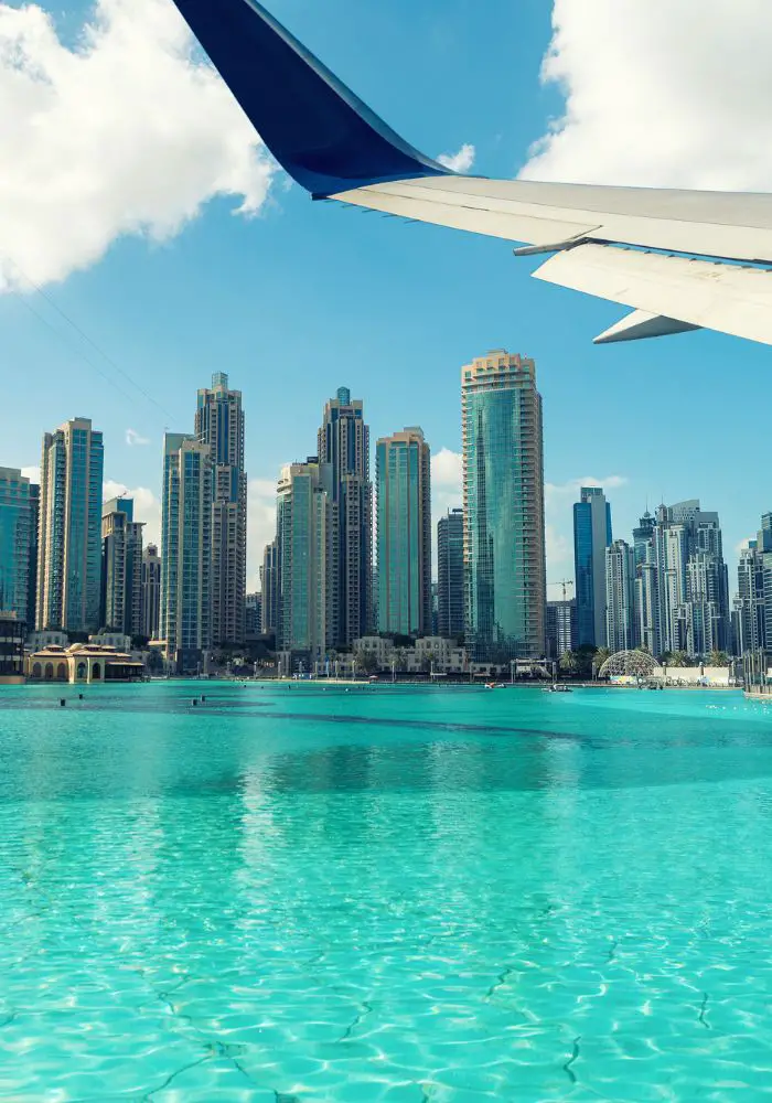 An airline in the Middle East flying over the blue water of the Dubai beaches. 