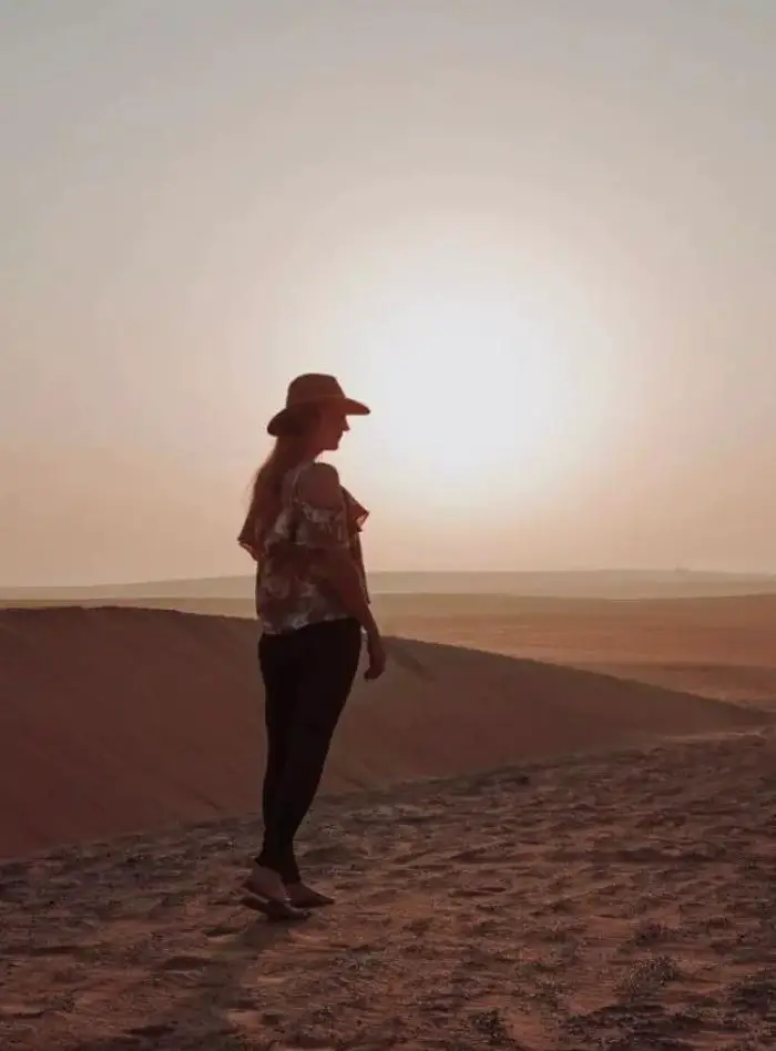 Monica in the Middle Eastern desert at sunrise.