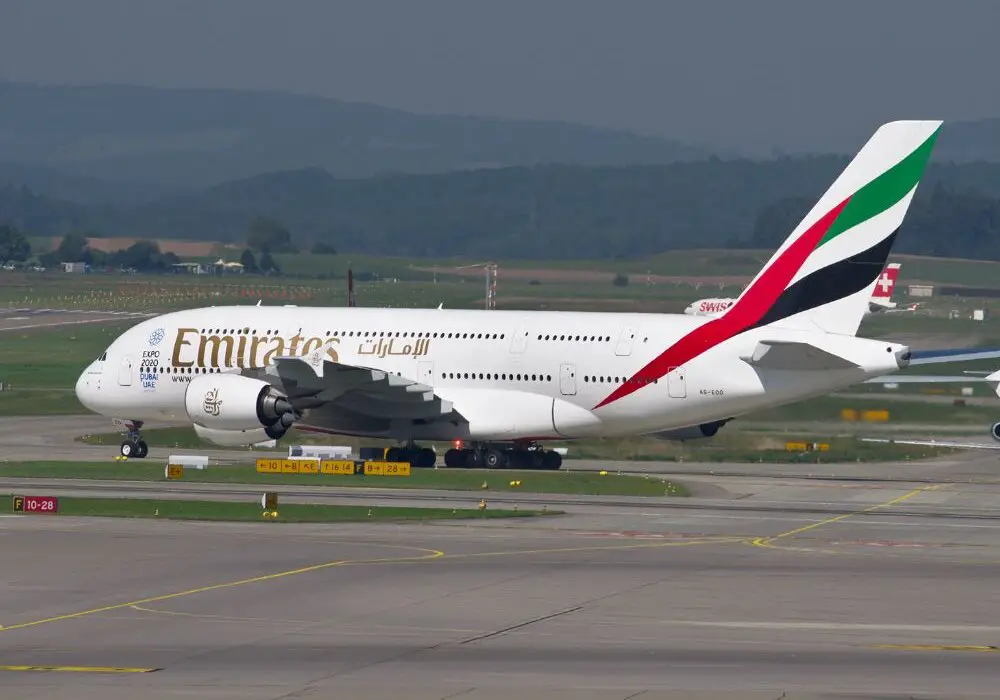 An airplane on the ground with the Emirates logo, one of the luxury airlines from the Middle East.