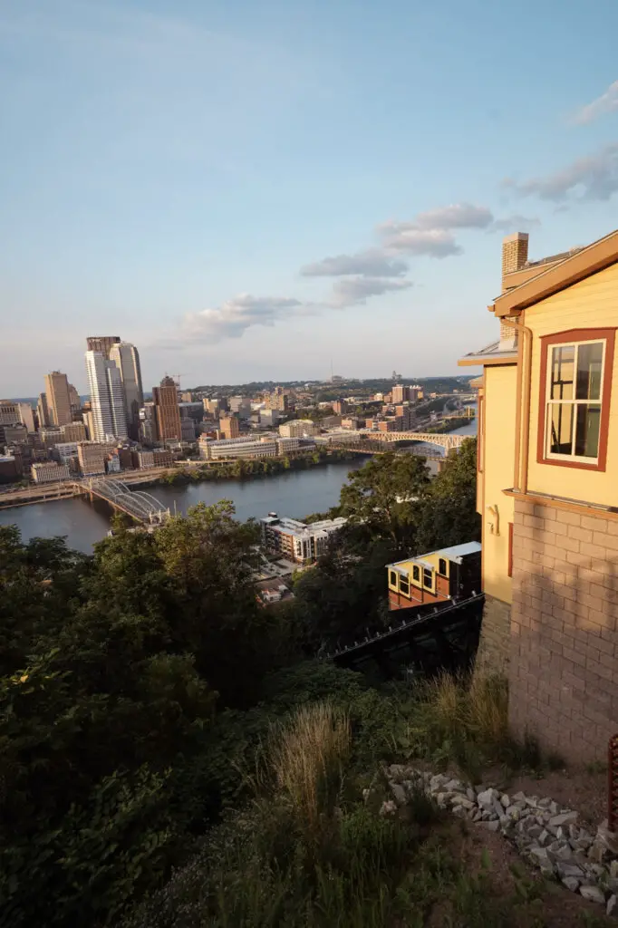 The red and yellow Monongahela Incline climbing up the tracks, one of the best things to do in Pittsburgh, PA.