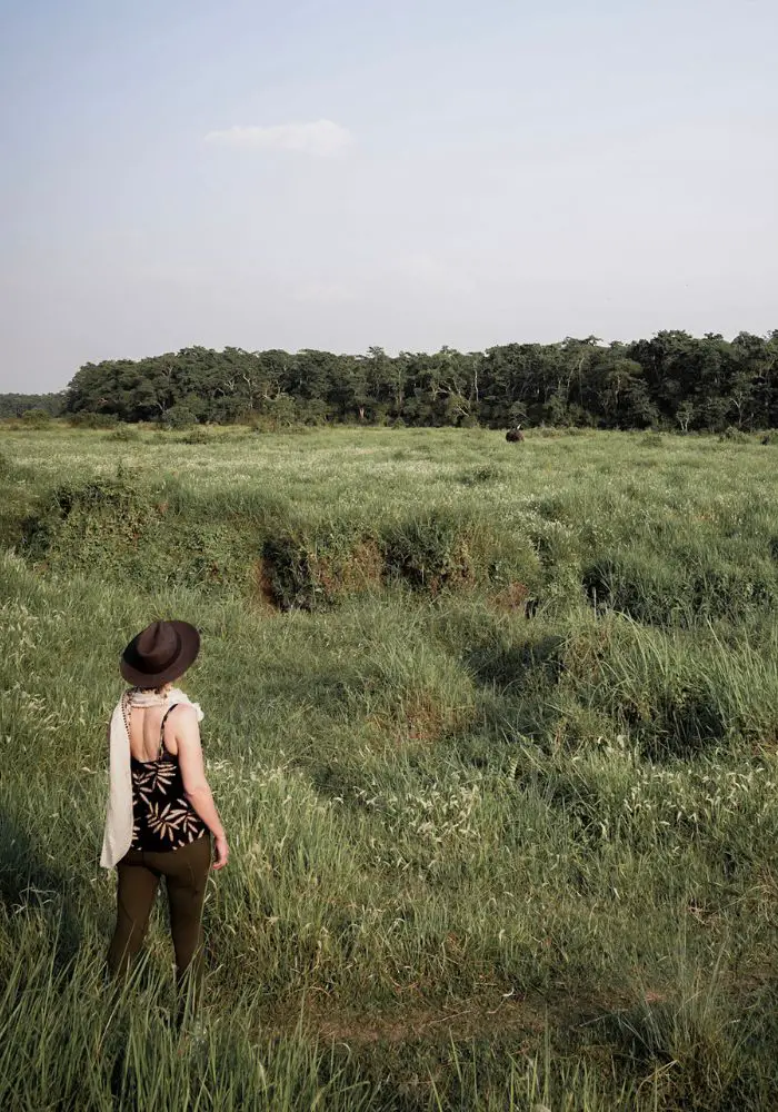 Monica on a Chitwan jungle safari, watching a rhino in the distance.