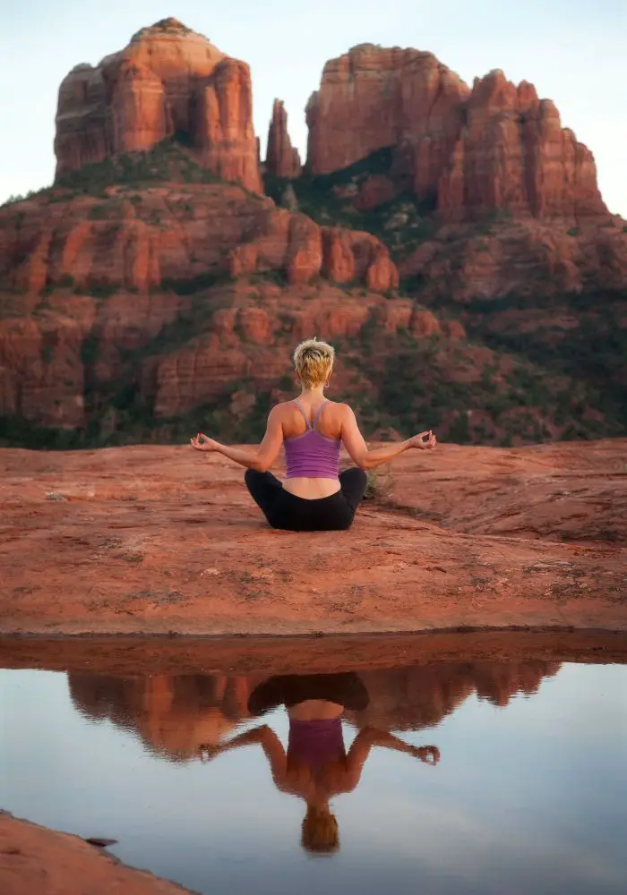 Girl meditating in the red rocks after sunrise - one of the most Unique Things To Do in Sedona, Arizona