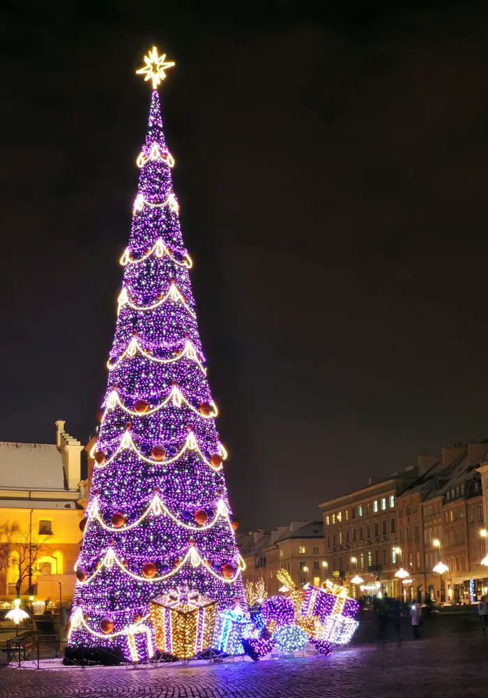 A nighttime Christmas in Warsaw scene with a glowing tree.