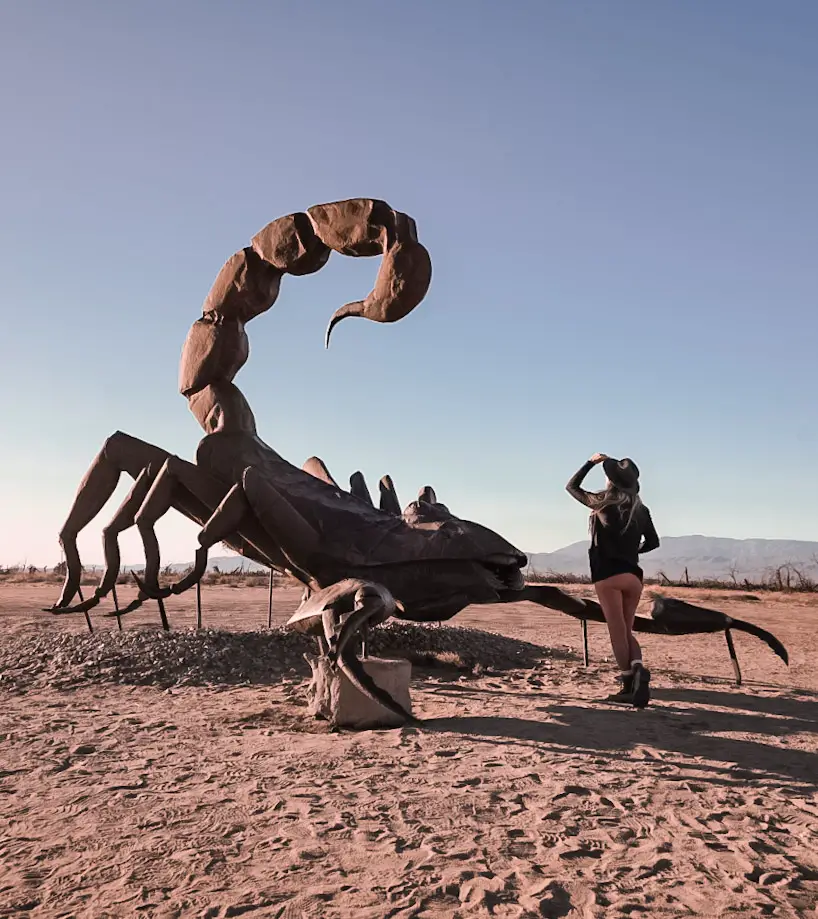 Monica next to a metal scorpion sculpture in Borrego Springs, one of the best weekend trips from San Diego.